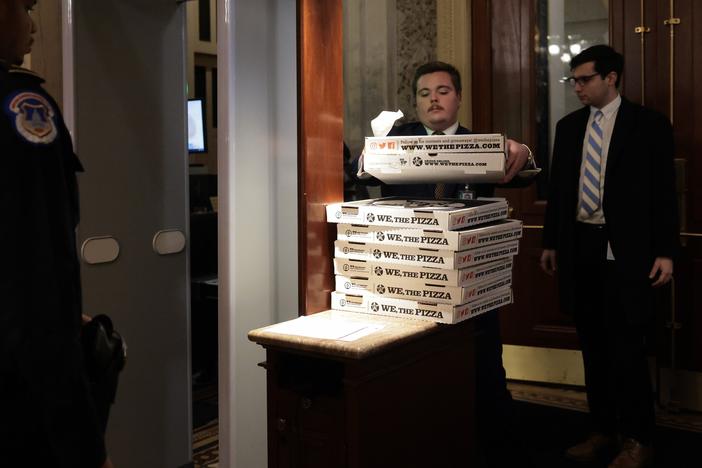 Workers bring boxes of pizza into the U.S. Capitol ahead of a Senate "vote-a-rama" on Feb. 20, 2025 in Washington, D.C.