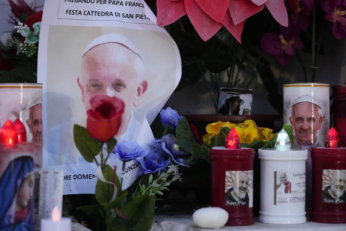 Candles are seen near pictures of Pope Francis outside the Agostino Gemelli Polyclinic in Rome, on Sunday, where the Pontiff is hospitalized since Feb. 14.
