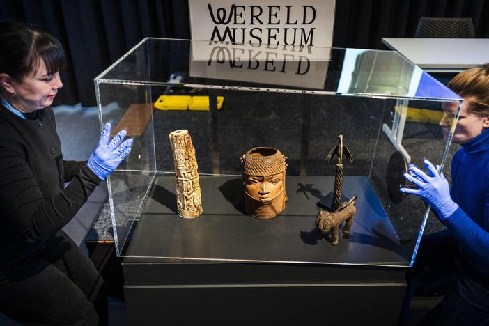 Employees open a glass case containing some of the 113 Benin Bronzes that are being returned to Nigeria after British troops looted them in the late 19th century, during a handing over ceremony at the Wereldmuseum (World Museum) in Leiden on February 19, 2025.
