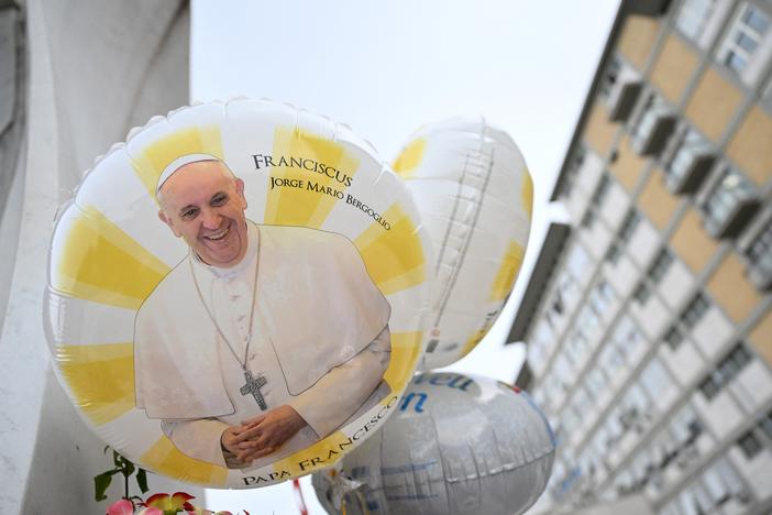Balloons depicting Pope Francis are laid at the statue of John Paul II outside the Gemelli hospital where Pope Francis is hospitalized, in Rome on Feb. 24, 2025. Pope Francis, in critical condition in hospital with pneumonia, had a good night and was resting, the Vatican said Monday.