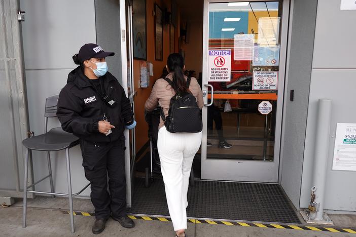 A security guard stands in front of the St. John's Community Health clinic in South Los Angeles.