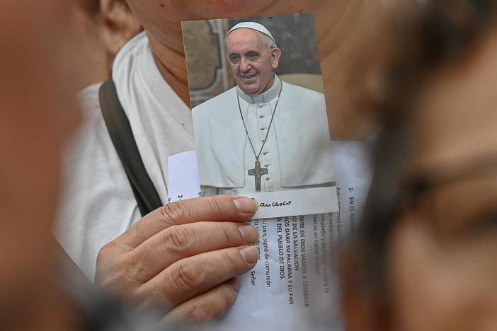 A worshipper carries a picture of Pope Francis as large crowds gather for Mass, led by Archbishop Jorge García Cuerva of Buenos Aires, to pray for the health of Pope Francis, in Buenos Aires, Argentina, Monday.