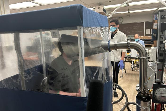 A person breathes inside the Gesundheit II, a machine that allows scientists to study the behavior of pathogens when they're exhaled. Research like this is at risk amid the Trump administration's proposed funding cuts.