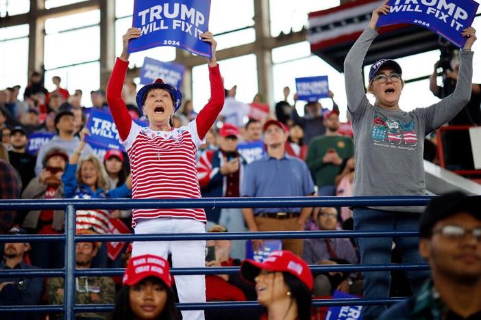 People hold up signs before Republican presidential nominee, former U.S. President Donald Trump holds a campaign rally Nov. 4, 2024 in Raleigh, North Carolina.