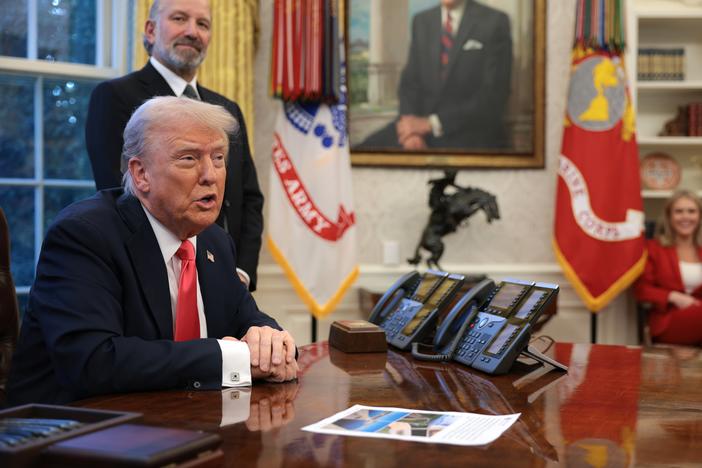 President Trump speaks to reporters as Commerce Secretary Howard Lutnick looks on in the Oval Office on Feb. 25, 2025.