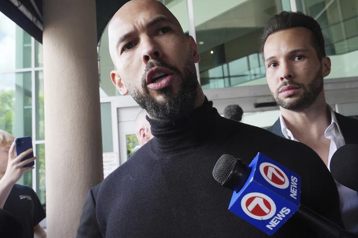 Andrew Tate (foreground) and his brother Tristan arrive in Fort Lauderdale, Fla., on Thursday, after Romanian authorities lifted travel restrictions against them.