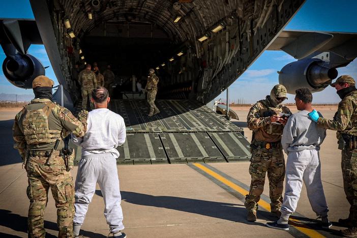 The Department of Homeland Security released photos of migrants as they boarded planes for Guantánamo Bay, Cuba.