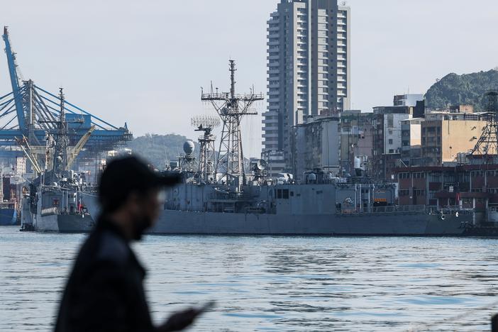 A man stands in front of Taiwanese navy ships anchored at the harbor in Keelung, near Taipei in northern Taiwan, on Dec. 11, 2024.