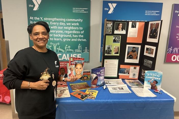 Gwen Partridge, known to her students as "Mrs. Gwen," stands in front of an exhibit she created for Black History Month on Feb. 13. She's hopeful others will be able to continue teaching Black history once she retires. The Trump administration has ordered that schools eliminate diversity initiatives or risk losing federal funding.