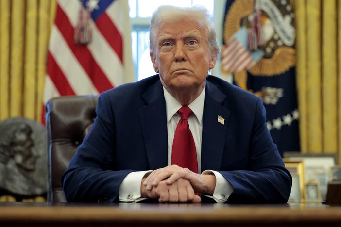 President Trump talks to reporters from the Resolute Desk on Jan. 30.