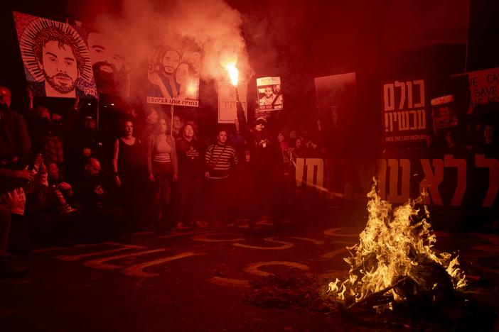 Freed hostage Ilana Gritzewsky holds a smoke torch as protesters set a fire during a demonstration calling for the release of all hostages held by Hamas in Gaza on Saturday in Tel Aviv. Israel's domestic security agency says it now had Hamas' battle plans and other warnings for the Oct. 7, 2023 attacks but failed to take them seriously.