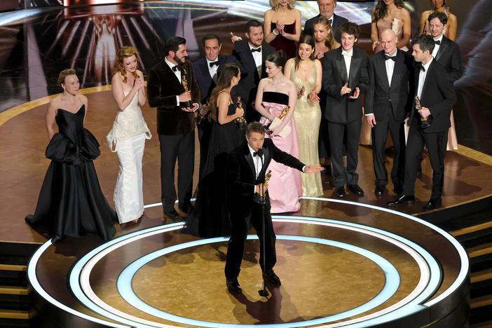 Cast and crew led by director Sean Baker accept the best picture award for <em>Anora </em>at the Oscars.