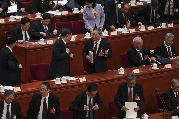 Chinese President Xi Jinping, center left, chats with his Premier Li Qiang as leaders and delegates prepare to leave after attending the opening session of the National People's Congress held at the Great Hall of the People in Beijing on Wednesday.