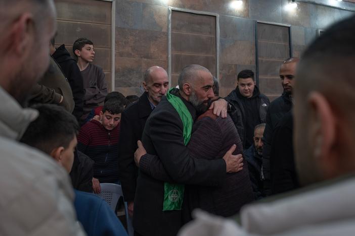 Ashraf Zughayer (center), a Palestinian who was released from Israeli prison during a ceasefire between Israel and Hamas, hugs his family in their home in Kfur Aqab, East Jerusalem, on Jan. 25.