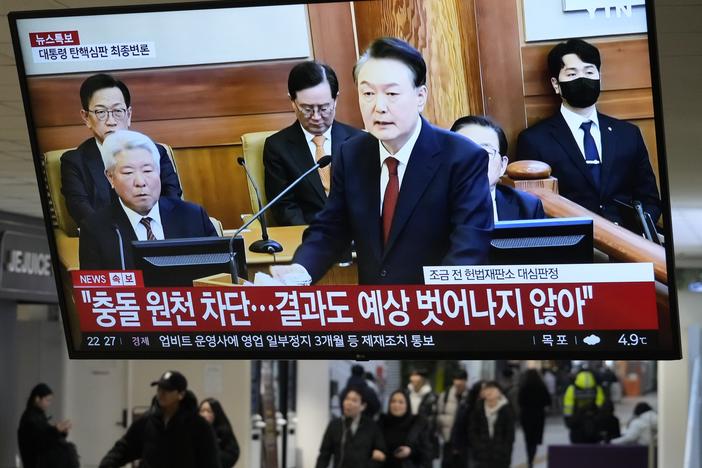 A TV screen shows footage of impeached South Korean President Yoon Suk Yeol's address at the final hearing of his trial during a news program at a bus terminal in Seoul, South Korea on Tuesday, Feb. 25, 2025.