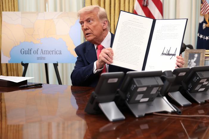 President Trump holds up an executive order after signing it in the Oval Office on March 6, 2025.