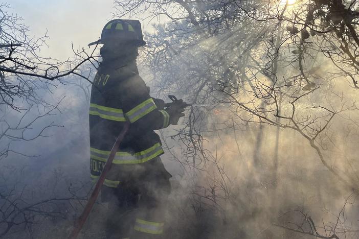 Firefighters respond to a brush fire in Suffolk County in New York's Long Island on Saturday.