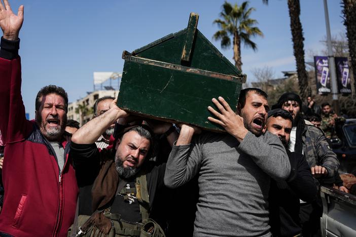 Syrian fighters and civilians carry the coffin of a member of the Syrian security forces during his funeral in Hama province on March 9.
