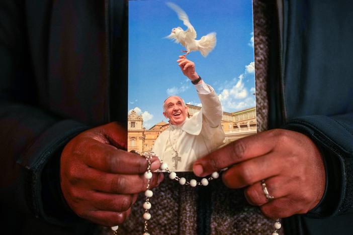 A priest holds a photograph of Pope Francis during the nightly rosary prayer service in St Peter's Square on Thursday, March 6 in Vatican City.