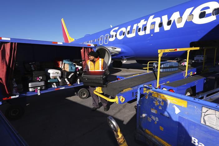 A Southwest Airlines plane is unloaded at Denver International Airport on Thursday, Feb. 27. The airline announced that it would begin charging some passengers to check bags.