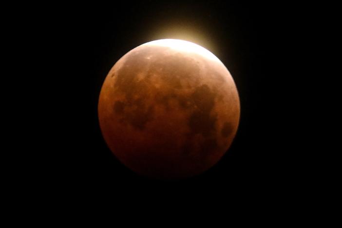 Light shines from a total lunar eclipse over Santa Monica Beach in California in 2021.
