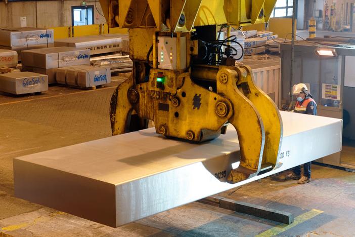 A worker manipulates a block of aluminum in a French smelter in 2022. President Trump has increased tariffs on imported aluminum from 10% to 25%, while also removing exceptions from tariffs on steel. Both metals are crucial raw materials for the automotive sector.