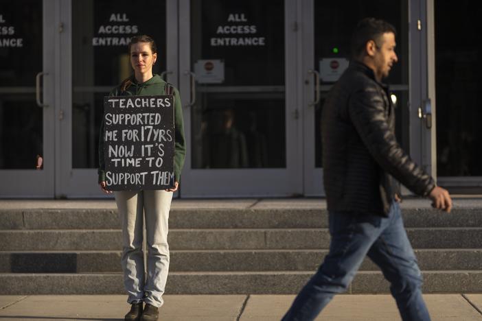 Chloe Kienzle of Arlington, Va., holds a sign as she stands outside the U.S. Department of Education, in Washington, D.C., on Wednesday – the day after the Trump administration announced widespread job cuts at the agency.