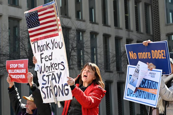 Protesters hold signs in solidarity at a rally in support of federal workers at the Office of Personnel Management in Washington, D.C., on March 4.
