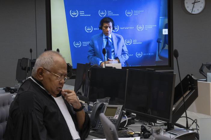Former Philippine President Rodrigo Duterte is seen on a screen with his lawyer Salvador Medialdea (left) in the courtroom during his first appearance before the International Criminal Court on charge of crimes against humanity over his deadly crackdown on narcotics, in The Hague on March 14.