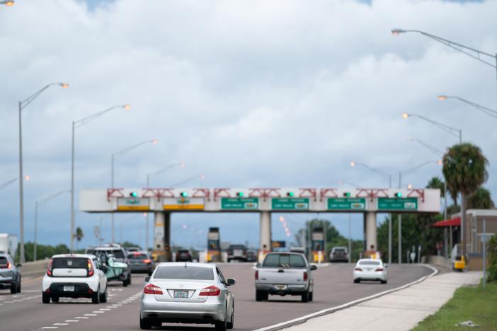 Motorists pass through a toll plaza near St. Petersburg, Florida. Bogus text messages threatening phone users with unpaid toll fees have spread rapidly — in part because scammers try to benefit from trends in travel and congestion pricing, an expert tells NPR.