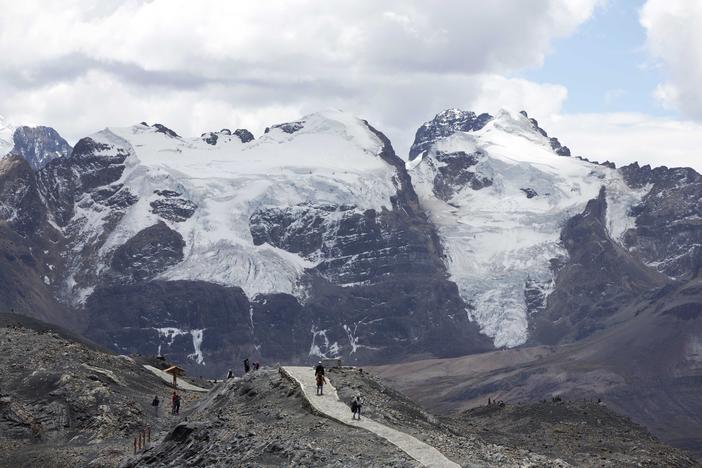Tourists walk in front of the Tuco glacier in Huascaran National Park during a tour called the "Route of climate change" in Huaraz, Peru, Aug. 12, 2016.