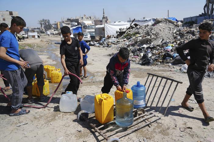 Young Palestinians fill cans with water in Jabaliya, northern Gaza Strip, on Sunday. Arab negotiators are trying to broker a ceasefire deal that would avert a return to fighting in Gaza and begin serious negotiations toward a formal end of the war, since the breakdown of the Israel-Hamas ceasefire deal at the beginning of the month.