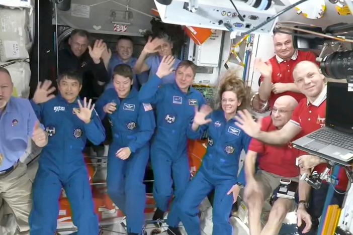This image made from video by NASA shows astronauts waving after a four-person crew arrived at the International Space Station on Sunday, March 16.