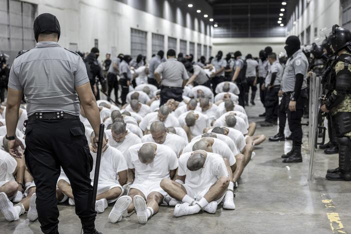 In this photo provided by El Salvador's presidential press office, a prison guard transfers deportees from the U.S., alleged to be Venezuelan gang members, to the Terrorism Confinement Center in Tecoluca, El Salvador on Sunday.