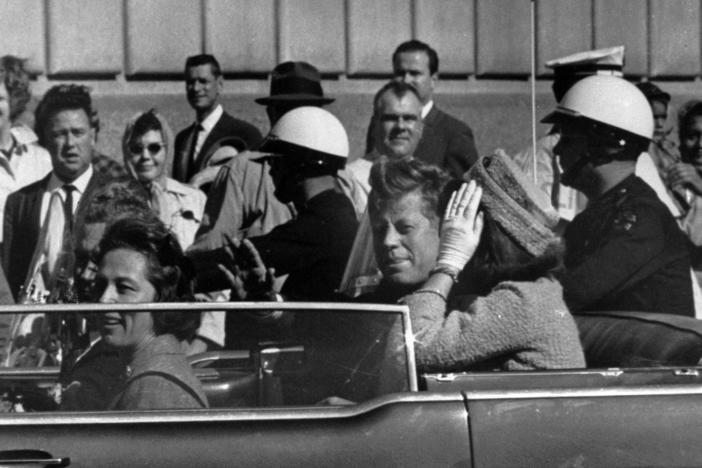 President John F. Kennedy is seen riding in his motorcade approximately one minute before he was shot in Dallas on Nov. 22, 1963.