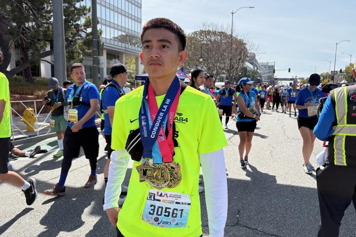 Abel Rivera wears his medals after finishing the LA Marathon on Sunday in Century City.