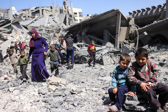 Children look on as people walk amid the rubble of a building destroyed in an overnight Israeli strike in Jabalia, in the northern Gaza Strip on Tuesday. Israel's deadly strikes on Gaza drew global condemnation, as it said it had "no alternative" other than to resume military operations in order to bring home hostages.