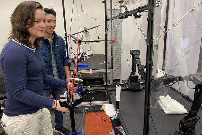 Chelsea Finn (left) and Moo Jin Kim conduct a demonstration with a robot at Stanford University.