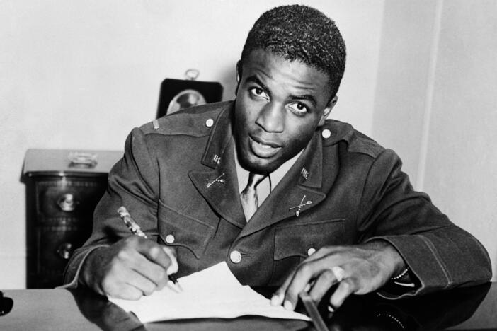 Jackie Robinson, shown here in military uniform signing a contract with a farm team for the Brooklyn Dodgers, is among the veterans whose Department of Defense webpages were removed — and then restored — as part of the Trump administration's scrubbing of references to DEI material.