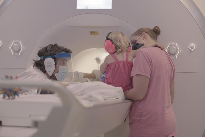 Yale cognitive neuroscientist Nick Turk-Browne works with a baby and parent during a brain scan.