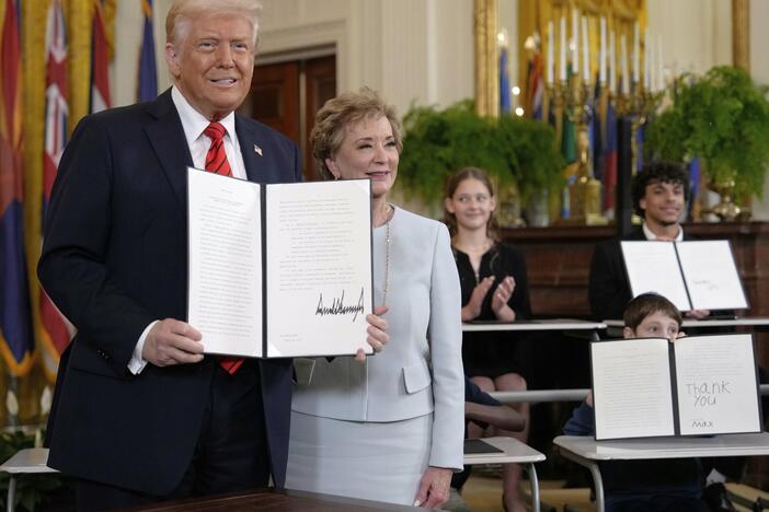 President Donald Trump holds up a signed executive order alongside Secretary of Education Linda McMahon in the East Room of the White House in Washington, Thursday, March 20, 2025.