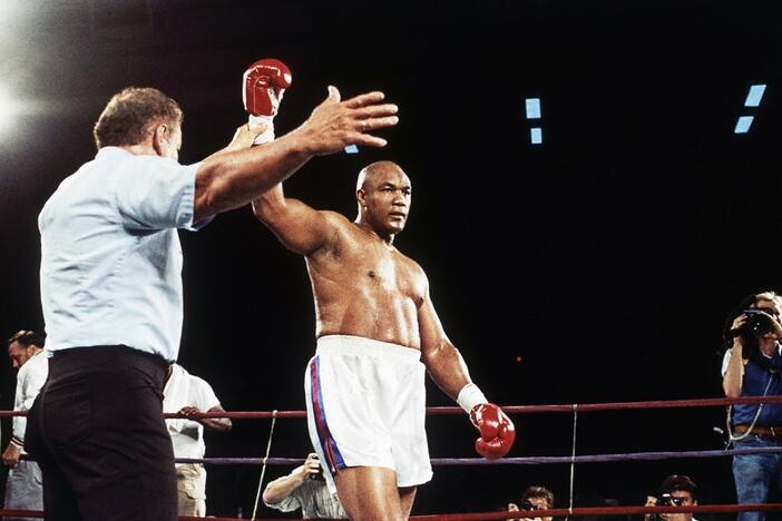 Former heavyweight champion George Foreman has hit glove lifted into the air after referee Al Munoz gave Foreman the victory in his heavyweight fight against Bert Cooper in Phoenix, on June 2, 1989.