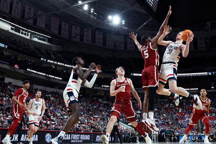 Liam McNeeley #30 of the Connecticut Huskies shoots the ball while defended by Mohamed Wague #5 of the Oklahoma Sooners during the first half in the first round of the NCAA Men's Basketball Tournament at Lenovo Center on March 21, 2025 in Raleigh, North Carolina.