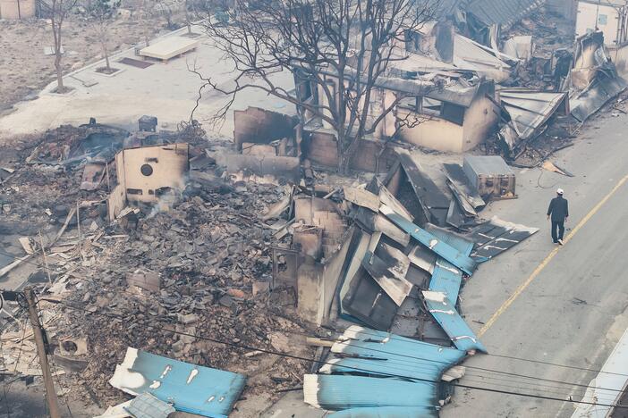 A man walks near a burnt-out house in a damaged village in Yeongyang, South Korea on Wednesday.