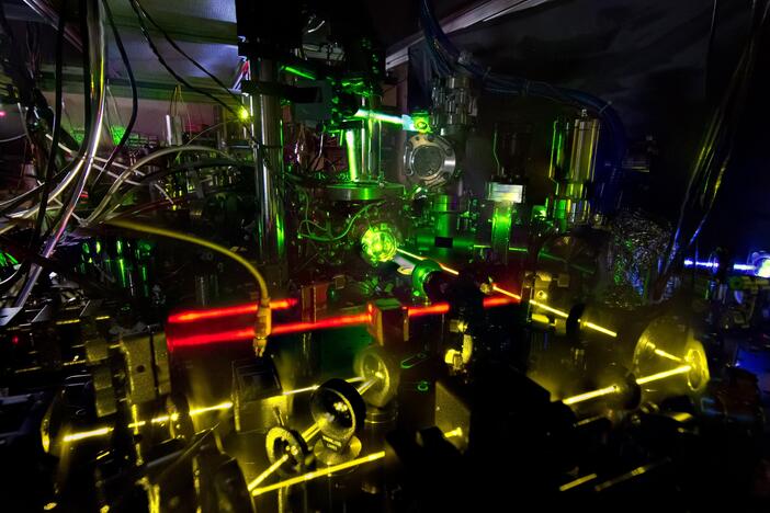 Lasers shine as part of an advanced atomic clock at NIST. Precise measurements of the colors of light emitted by atoms are essential to everything from atomic clocks to medical devices.