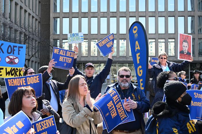 Protesters hold signs in solidarity with the American Federation of Government Employees at a March 4 rally in support of federal workers at the Office of Personnel Management in Washington, D.C.