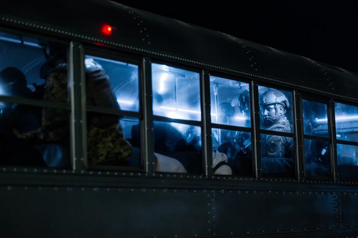 A member of the Salvadoran army stands guard on a bus with inmates at CECOT on March 16 in Tecoluca, El Salvador.