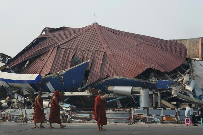 Buddhist monks walk past a collapsed building after a powerful earthquake in Naypyitaw, Myanmar, on Saturday.