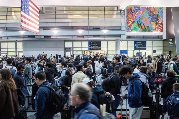Travelers wait in the security line at Boston Logan International Airport in Boston on Dec. 21, 2023.