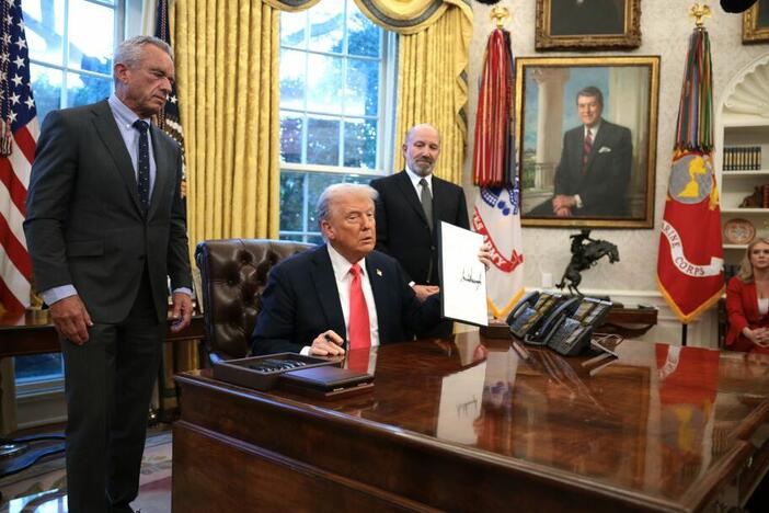 President Trump, joined by Health and Human Services Secretary Robert F. Kennedy Jr. (left) and Commerce Secretary Howard Lutnick (right), signs an executive order on Feb. 25 on price transparency requirements for the health care industry.